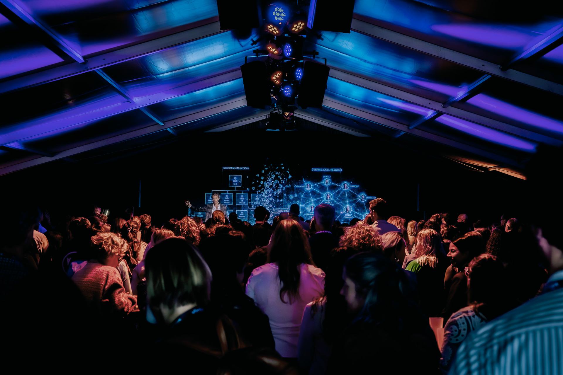 Full auditorium with Laurens Waling on stage, seen from the back row
