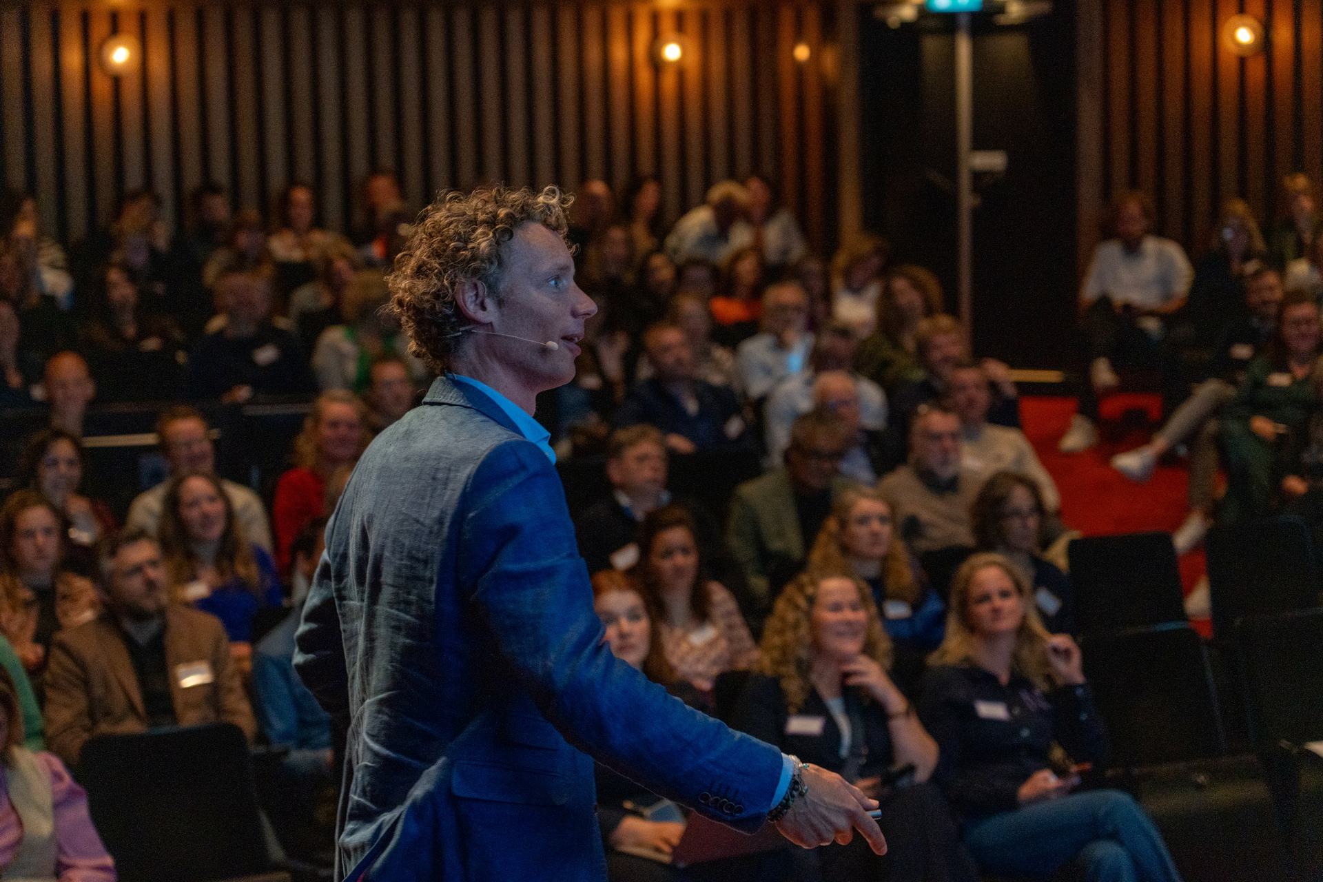 Laurens Waling wearing a headset microphone, speaking energetically to the room