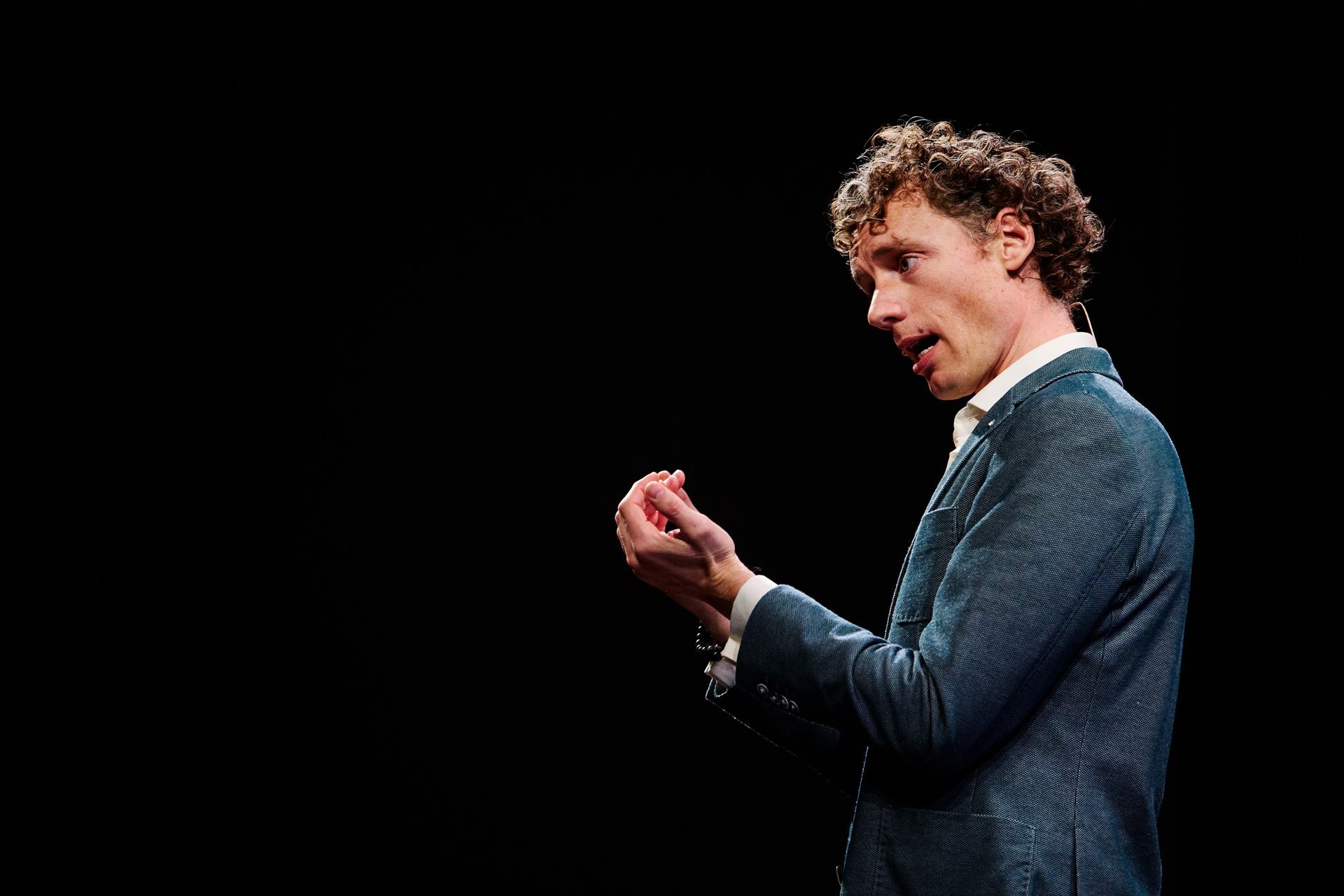 Laurens Waling making an expressive hand gesture during a keynote