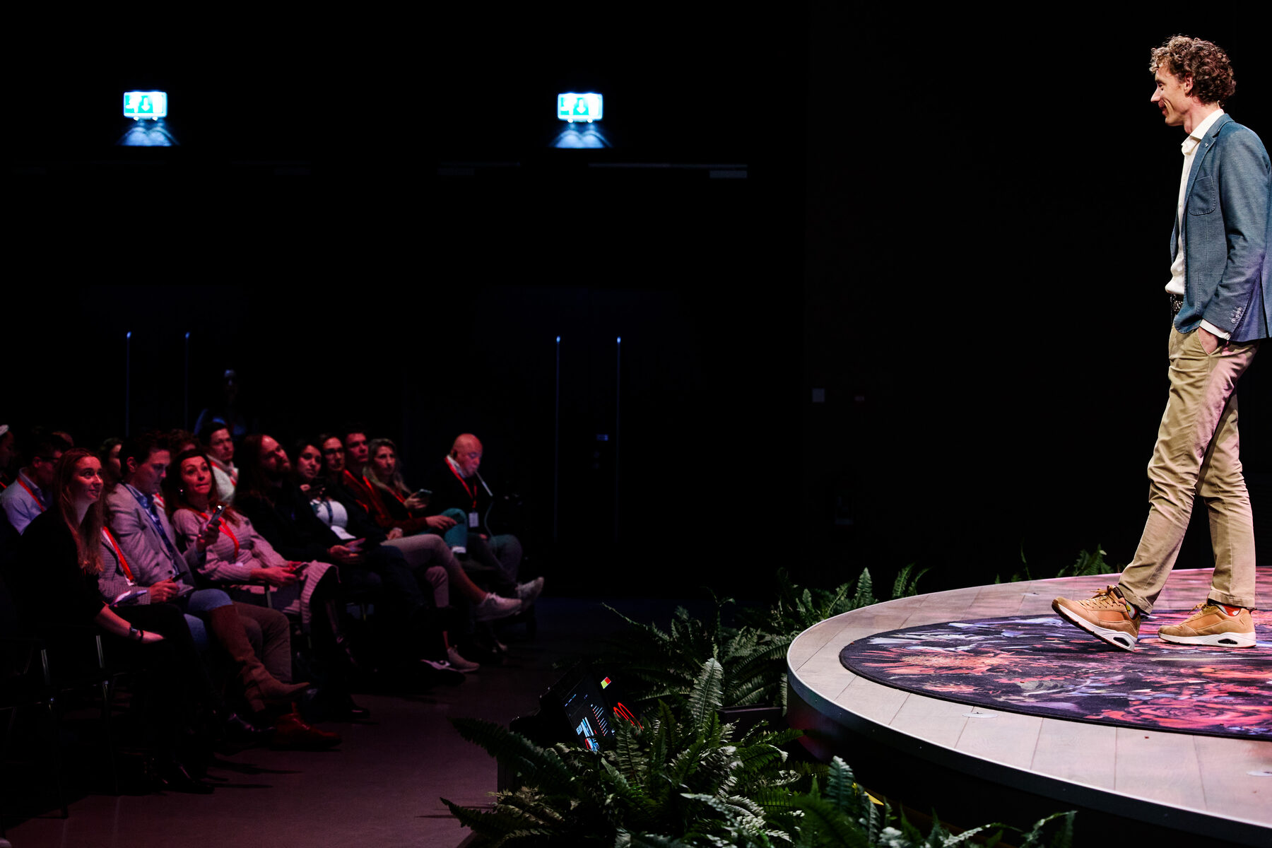 Laurens Waling op een rond podium, in gesprek met een volle zaal