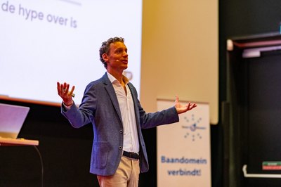 Laurens spreekt met open armen op het podium