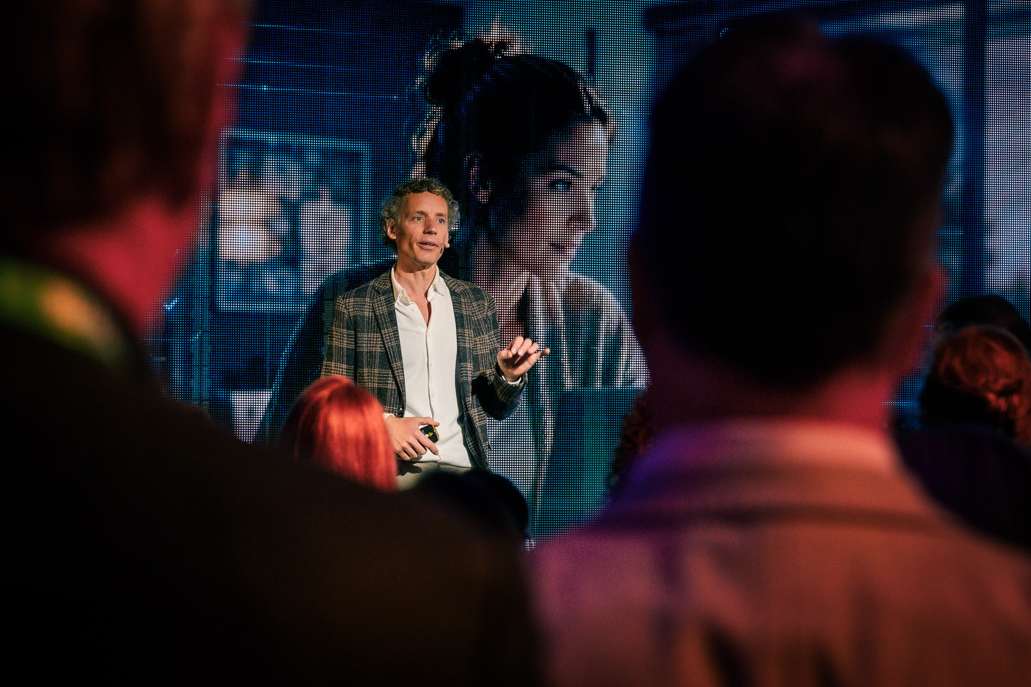 Laurens Waling in conversation with the room, a large portrait on the screen behind him